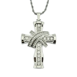 Détail d'un pendentif croix argenté avec des zircons brillants et une chaîne torsadée
