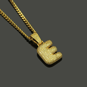Close-up of hip hop style gold plated 'E' letter pendant necklace with cubic zirconia
