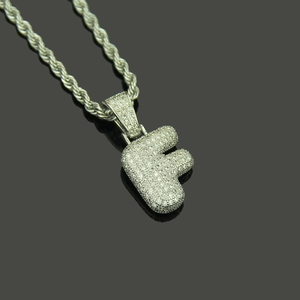 Macro view of silver color letter F pendant with micro-pave cubic zirconia and rope chain
