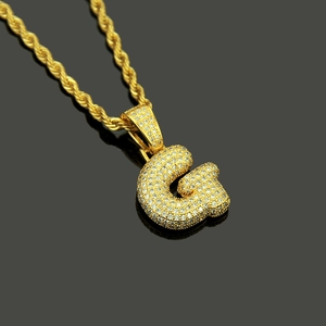 Macro shot of gold hip hop letter G pendant necklace with cubic zirconia micro-paving