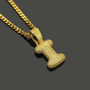 Macro shot of gold-plated letter I pendant with pave-set crystals on cuban link chain