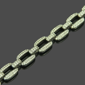 Close-up of hip hop silver chain links with pave-set rhinestones on reflective surface