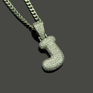Close-up of silver iced-out letter J pendant with micro-pave cubic zirconia on Cuban chain