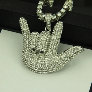 Close-up of hip hop pendant featuring iced out hand gesture with sparkling tennis chain