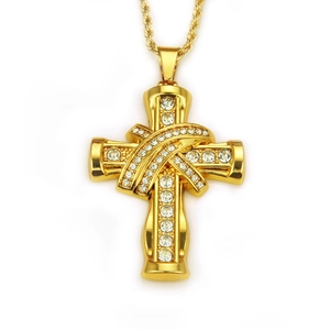 Détail d'un pendentif croix doré orné de strass sur une chaîne en corde dorée