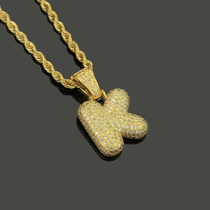 Macro shot of gold-plated letter K pendant with micro-pave cubic zirconia on rope chain