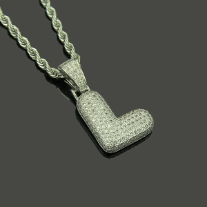 Close-up of hip hop silver letter L pendant with iced-out zircon on a rope chain