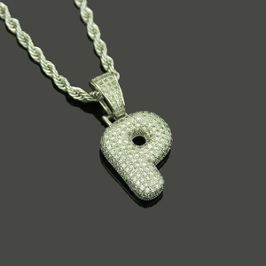 Macro view of iced out letter P pendant with micro paved cubic zirconia and rope chain