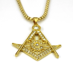 Détail macro du pendentif maçonnique plaqué or avec cristaux et lettre G sur chaîne