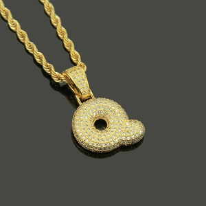 Macro shot of hip hop letter Q pendant with iced out cubic zirconia on a rope chain