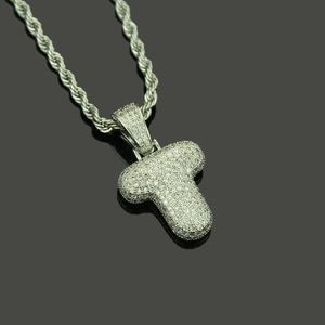 Macro detail of silver hip hop T letter pendant with pavé cubic zirconia on rope chain