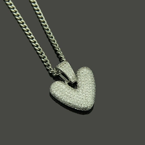 Close-up of hip hop heart pendant with white zircon micro-pave and silver Cuban chain