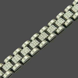 Macro detail of silver watch-style bracelet with pavé-set crystals and brushed metal links