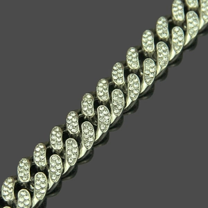 Close-up of a silver Cuban link bracelet with pavé-set crystals and polished finish