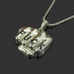 Détail macro du pendentif poing américain en acier inoxydable argenté avec gravure