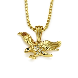 Macro detail of golden eagle pendant necklace with sparkling rhinestones and box chain