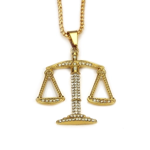Détail macro du pendentif balance hip-hop doré serti de cristaux brillants étincelants