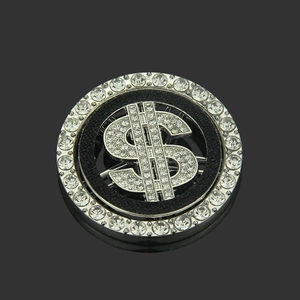 Close-up of a silver dollar sign accessory with white rhinestones and a rotating base