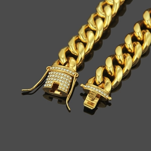 Macro view of gold Cuban link bracelet with iced-out rhinestone buckle and secure clasp
