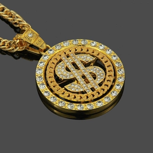 Gros plan macro d'un pendentif signe dollar doré rotatif avec des strass étincelants