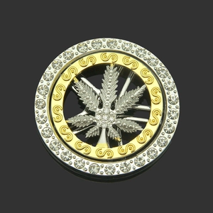 Gros plan d'un pendentif feuille d'érable rotatif avec strass brillants et détails dorés