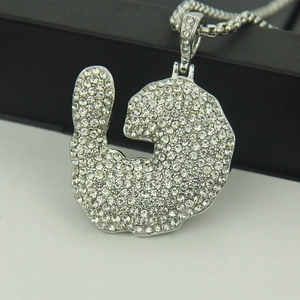 Vue macro d'un pendentif hip hop argenté avec zircons et chaîne à mailles carrées
