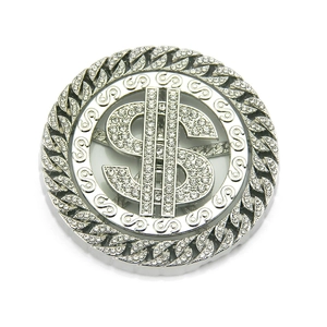 Macro detail of rotating dollar sign hip hop accessory with iced out crystals on silver alloy
