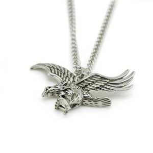 Vue détaillée du pendentif aigle vintage en argent avec des ailes gravées sur chaîne