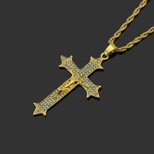 Vue macro du pendentif croix dorée avec diamants micro-pavés et crucifix sur chaîne