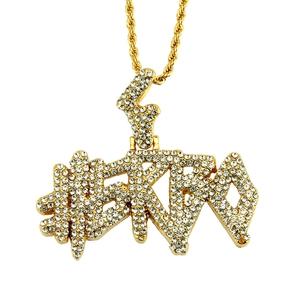 Detail of hip hop gold pendant necklace featuring white iced-out pavé crystal letters
