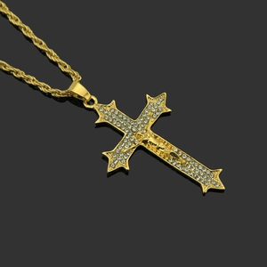 Pendentif croix crucifix doré hip hop serti de diamants avec chaîne torsadée sur fond noir poli