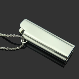 Macro view of silver metal lighter-shaped pendant with thick rope chain on black surface