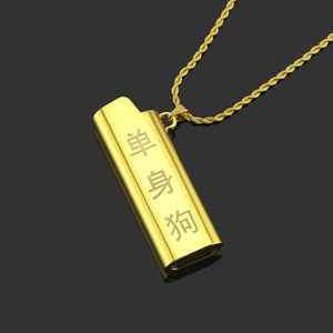 Macro detail of gold lighter pendant necklace with Single Dog engraving on black surface