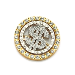 Detail of a rotating dollar sign accessory with rhinestones in gold and silver plating