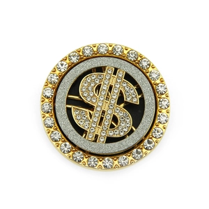 Close-up of a rotating dollar sign accessory with sparkling crystals and gold finish