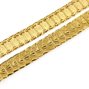 Detail of gold hip hop bracelets featuring heart-embossed patterns and industrial links