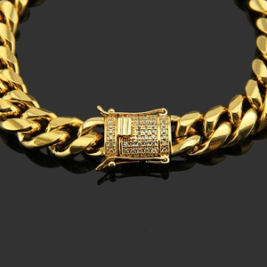 Macro shot of gold Cuban link bracelet featuring a micro-paved zircon box clasp buckle