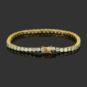 Macro shot of gold tennis bracelet with cubic zirconia on reflective black surface