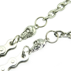 Macro shot of silver punk pant chain featuring detailed skull charms and metal roller links