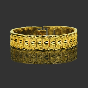 Retro golden wide link bracelet with embossed heart and leaf patterns on a mirrored surface
