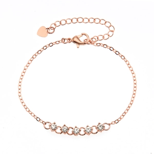 Detail of rose gold bracelet featuring five round rhinestones and heart charm extender