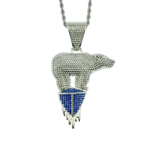 Macro detail of polar bear pendant with blue and white crystals on silver rope chain