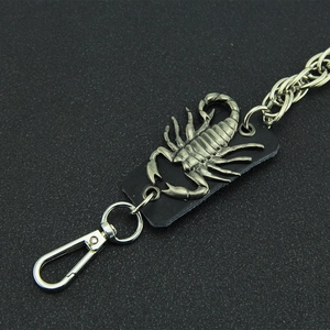 Vue macro d'un pendentif scorpion punk et d'une chaîne de pantalon en métal argenté