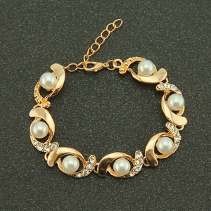 Elegant gold pearl bracelet with sparkling rhinestones on a charcoal textured display