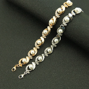 Elegant pearl and rhinestone wave bracelet in gold and silver finish with lobster clasp