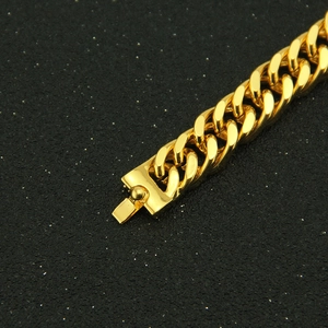 Macro detail of polished gold Cuban link bracelet with secure fold-over clasp