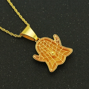 Vue macro du pendentif fantôme hip hop doré avec texture quadrillée et chaîne torsadée