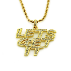 Makroaufnahme des Goldanhängers im Hip-Hop-Stil mit LET'S GET IT und Strasssteinen