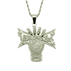 Dettaglio del ciondolo a pugno hip hop argento con scritta Real Rich e cristalli incastonati