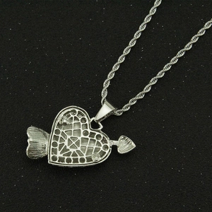 Macro detail of silver heart pendant back showing hollow grid and rope chain texture